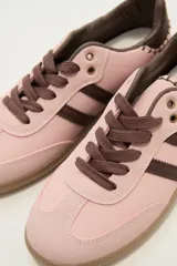 Zapatillas deportivas color rosa con detalles en marrón, cordones marrones y suela color caramelo.