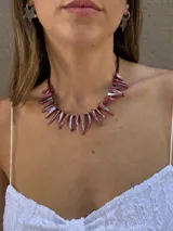 Collar corto compuesto por bastones de nácar teñidos de color rosado iridiscente, unidos por mostacillas oscuras.