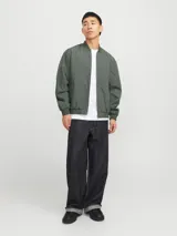 Campera bomber verde militar, de manga larga con cuello baseball y fit cómodo. Diseño con cierre frontal de cremallera, bolsillos delanteros funcionales y puños de canalé.