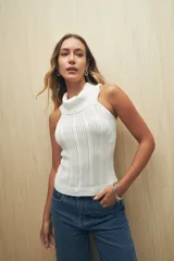 Top tejido de punto color beige, con cuello alto y diseño sin mangas.