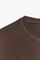 Camiseta color ladrillo de algodón, corte regular, cuello redondo y manga corta.