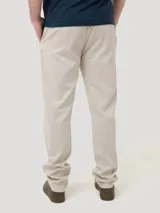 Pantalón de gabardina color beige, corte recto, con bolsillos laterales y traseros. Se ajusta a la cintura con botón y cierre.