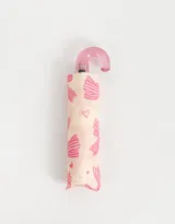 Paraguas corto con estampa de moños y corazones rosas sobre fondo crema, con mango curvo de plástico transparente color rosa.