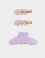 Set de accesorios para el pelo que incluye un broche curvo y dos broches tipo pico de pato con diseño ondulado, todos en acrílico color lila con efecto marmolado.