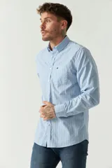 Camisa celeste a rayas rojas de hombre, manga larga, con bolsillo y logo bordado.