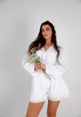 Conjunto blanco simil lino, compuesto por una camisa de manga larga con cuello clásico y un short con cintura elastizada.