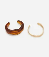 Kit de dos brazaletes rígidos, uno de metal dorado con efecto martillado y otro de resina color carey con forma orgánica.