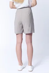 Short color grisáceo con cinturón de la misma tela, tiro alto y corte holgado.