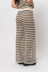 Pantalón tejido a rayas horizontales en hilo de algodón color crudo y negro, con calado abierto, cintura elastizada y corte recto ancho.