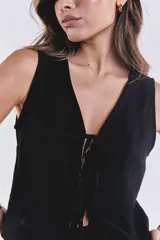 Chaleco negro con escote en V y lazo de ajuste frontal.