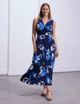 Vestido largo de seda fría con estampado floral en tonos azul y blanco. Tiene escote en V cruzado, cintura con faja plisada y detalles con relieve.