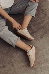 Zapatillas bajas de cuero color marrón con suela de goma color caramelo y cordones marrones.