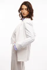 Blazer blanco de corte entallado, con solapas, cierre de un botón y bolsillos con tapa. Confeccionado en tela de sastrería noble.