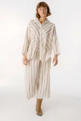 Camisa celeste y blanca a rayas verticales, de corte holgado y mangas largas.