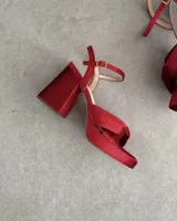 Sandalia de cuero vacuno color dorado, con plataforma y taco cuadrado. Presenta una tira delgada en el tobillo y detalle de nudo en la capellada.