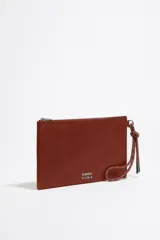 Neceser de piel color marrón con asa de mano de cordón extraíble, logo metálico plateado, bolsillo interior y cierre con cremallera. Interior con etiqueta de tejido Bimba y Lola.