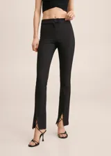 Calzas negras de poliéster, viscosa y elastano, con corte ajustado y aberturas en el ruedo.