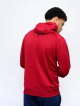 Campera de entrenamiento con capucha, cierre frontal y puños y cintura de tela acanalada. El cuerpo de la campera es azul con un estampado moteado en tonos de azul más claro, mientras que las mangas y la capucha son de color azul liso. Lleva el escudo del Club Nacional de Football y el logo de Umbro bordados en el pecho.