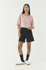 Blusa color rosa con estampado de flores blancas, escote redondo y mangas 3/4.