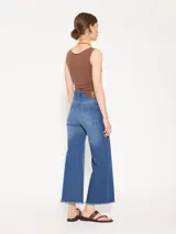 Pantalón de jean azul de tiro medio, corte recto y largo cropped con terminación desflecada.