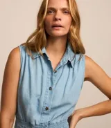 Vestido midi de jean celeste, sin mangas, con cuello camisero, abotonado al frente y con lastex en la cintura.