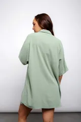 Camisa larga color beige con botones y cuello.