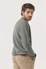 Sudadera verde militar de corte clásico, cuello redondo y mangas largas.