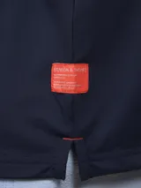 Polo de piqué azul marino, de corte clásico, con cuello abotonado y mangas cortas.