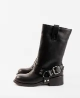 Bota de cuero marrón oscuro con caña media, estribo desmontable y hebilla metálica. Taco de madera de 5cm y suela de caucho.