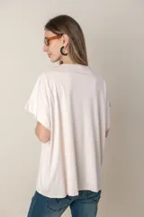 Remera holgada color beige, de escote en V y mangas cortas.