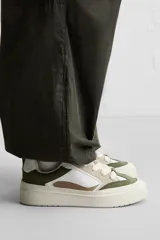 Zapatillas deportivas blancas de estilo skate con cordones gruesos y suela con plataforma.