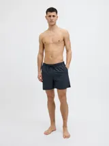 Short de baño azul marino con cintura elástica, cordón ajustable, bolsillos delanteros y trasero. Confeccionado en tejido plano de nylon y poliéster.