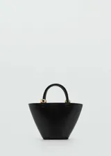 Bolso pequeño color negro con forma trapezoidal, efecto piel y asa de mano. Incluye asa larga tipo bandolera desmontable, cierre oculto de mosquetón, detalle de aro metálico y forro interior.