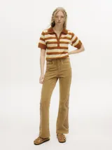 Pantalón de jean gris oscuro con corte oxford y apliques metálicos alrededor de los bolsillos y en la parte externa.