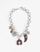 Collar plateado de cadena gruesa con dijes colgantes de estrella, corazón, herradura y cuerno.