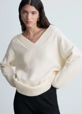 Sweater color beige de tejido de punto con cuello en V y corte oversize.