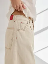 Bermuda color marrón claro, de tiro medio/alto, calce cómodo y relajado, con detalle de voladito en bolsillos.