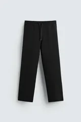 Pantalón jogger negro de corte recto, confeccionado en tejido interlock de algodón con cintura elástica ajustable con cordón, bolsillos frontales y traseros de vivo.
