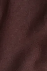 Pantalón sastrero color marrón chocolate, tobillero, de tiro alto, con cierre y botón. Presenta bolsillos al bies, bolsillos traseros decorativos y piernas amplias con pliegues adelante y atrás.