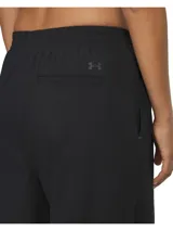 Pantalón negro de tejido técnico, corte ancho, con cintura elástica y pliegues frontales.