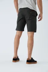 Bermuda de gabardina azul marino con logo bordado, bolsillos laterales y traseros, cierre con cremallera y botón, y presillas para cinturón.