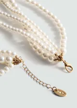 Collar corto de perlas sintéticas color crema, con múltiples hilos y cierre de mosquetón dorado.