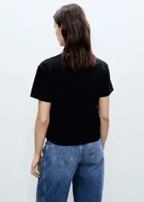 Camiseta blanca de algodón con cuello redondo, mangas cortas y diseño calado con bordado de lunares.
