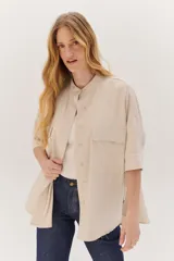 Sobrecamisa celeste de corte recto, con cuello mao, mangas 3/4 con puños y cierre frontal con botones. Tiene dos bolsillos de parche en el pecho.