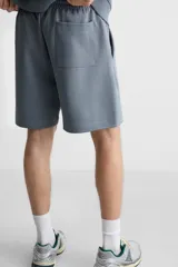 Bermuda negra relaxed fit confeccionada en tejido interlock de algodón con elasticidad. Cintura elástica ajustable con cordón. Bolsillos laterales y detalle de bolsillo trasero de plastrón.