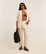 Pantalón de vestir color beige, de corte recto, con cintura elástica ajustable con lazo y bolsillos laterales.