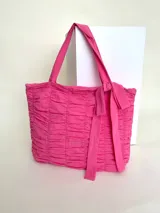 Bolso tipo tote color fucsia, 100% algodón, con diseño drapeado, moña fija y grifa de acrílico Cilento.
