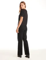 Blusa negra de modal con cuello a la base y espalda con abertura de ojal y botones. Presenta apliques de lentejuelas en el cuello y las mangas.