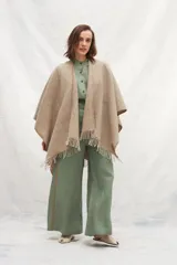 Ruana beige de lana con flecos.