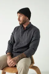 Camisa de hombre color marrón con efecto stone wash, fit regular, cuello americano, cierre con botones, dos bolsillos frontales con botón y mangas largas con puños abotonados.